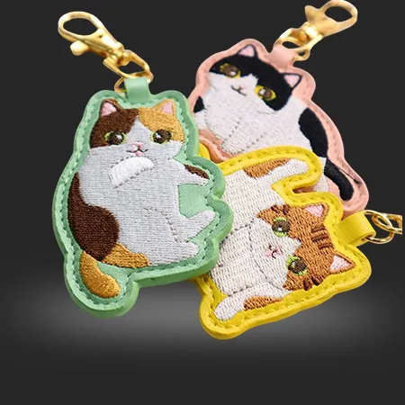 Custom embroidered keychains made from fabric with stitched logo design