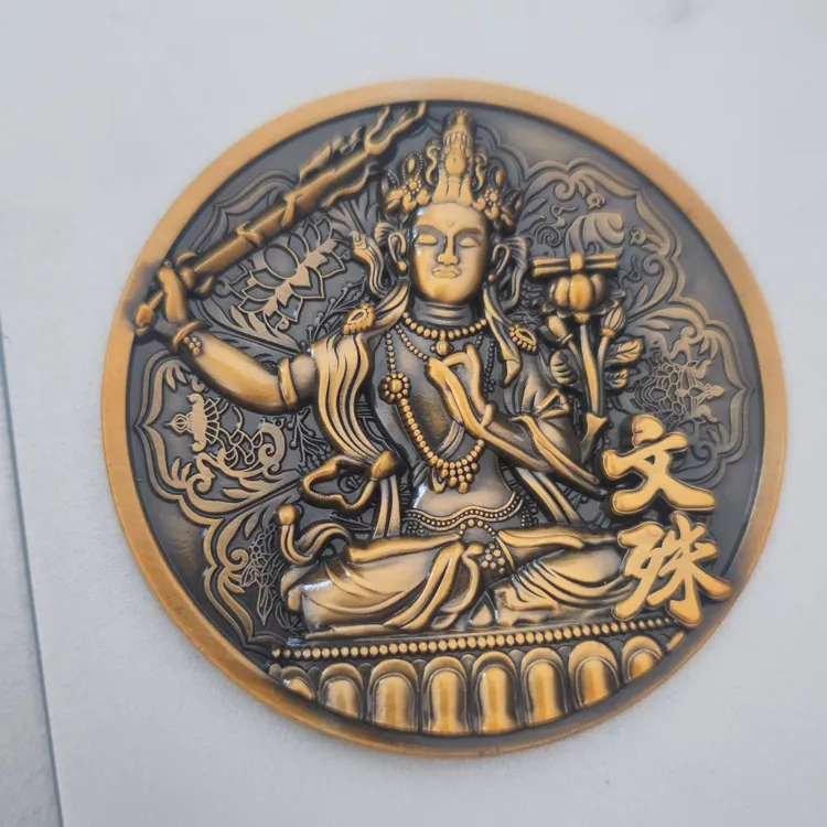 A bronze-toned artistic medal featuring a detailed high-relief carving of Manjushri Bodhisattva seated on a lotus throne holding a sword. Large gold Chinese characters for "Manjushri" (文殊) are displayed on the right.